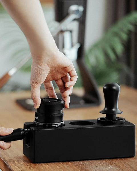 Hand using Walnut 4 In 1 Espresso Knock Box And Tamping Station With Portafilter Holder Tamper Holder And Distributor Holder For 51 To 54 Mm Espresso Gear