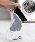 Breathable Mesh Sports Equipment Bag 12x18 Inch, Heavy Duty Nylon Drawstring Gear Sack used to hold laundry items near a washing machine.