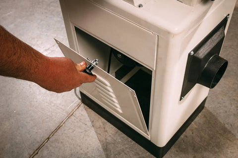 User adjusting the access panel of the six inch long bed jointer featuring helical cutterhead and 27 carbide inserts.