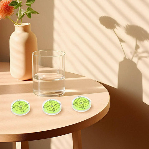 Four Pack Mini Bubble Level Ruler Set on a table with glass and vase, high precision compact plastic design for DIY projects