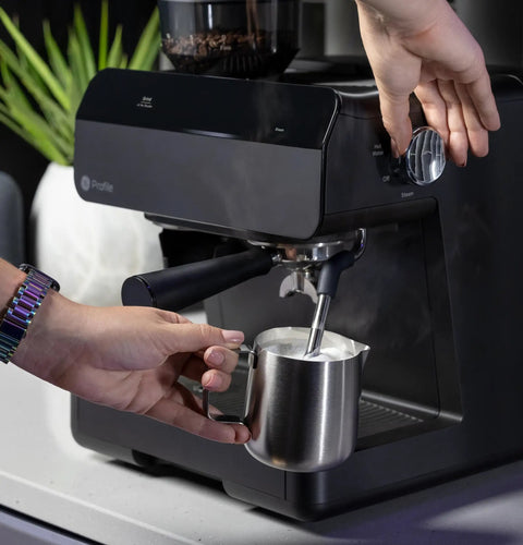 User operating the steam frother on the Next Level Semi Automatic Espresso Machine With Built In Grinder in slick black.