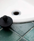 Kick Clogged Tubs To The Curb With This Game Changing Hair Catcher Combo Pack features a silicone stopper on bathroom tiles.