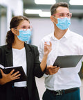 Two people wearing pink protective safety glasses with anti fog coating and anti scratch lenses unisex fit, indoors.