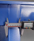 Close-up measuring Tough As Nails Steel Workbench material thickness with caliper for precision machining work.