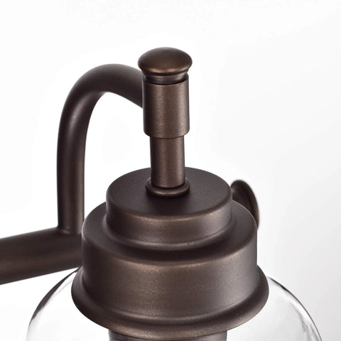 Adair 3 Light Bath Vanity Light in oil-rubbed bronze with clear glass detail, close-up of fixture top, 24-inch wide transitional indoor fixture