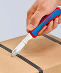 Person using Everyday Carry Folding Knife With Ultra Sharp Solingen Blade, Tough Ergonomic Handle, on cardboard box