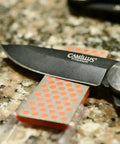 Pocket Diamond Sharpener With Monocrystalline Diamond Surface under knife blade on countertop
