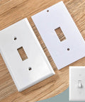 Universal Foam Outlet Insulation Pads And Draft Sealers For Electrical Outlets And Light Switch Covers, Cut To Fit 2.5 By 4 Inches, White, Easy Install Wall Gasket Kit For Energy Saving And Draft Blocking shown next to a white switch plate on wood surface.