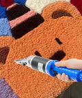 Top Shelf Electric Craft Scissors engineered for sharp carpet carving, used on multicolored rug design for precise trimming.