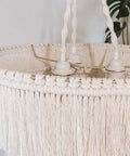 Close-up of the Boho Fringe Chandelier Pendant Light for Nursery or Bedroom with cream fringe and gold metal frame.