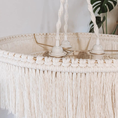Close-up of the Boho Fringe Chandelier Pendant Light for Nursery or Bedroom with cream fringe and gold metal frame.