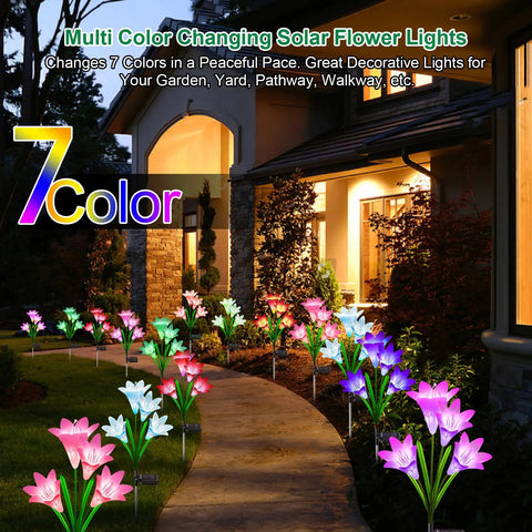 Lit Seven Color Changing Solar Lily Garden Lights With 24 LED Petals illuminating a pathway in a garden setting at night