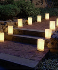 White Plastic Luminaria Lanterns Pack Of 100 With Printed Design For Indoor And Outdoor Use All Weather Ready Pathway Lighting 5.75 Inch Long By 3.5 Inch Wide By 10 Inch Tall Battery Operated Light Not Included lighting a stone pathway at night.