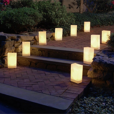 White Plastic Luminaria Lanterns Pack Of 100 With Printed Design For Indoor And Outdoor Use All Weather Ready Pathway Lighting 5.75 Inch Long By 3.5 Inch Wide By 10 Inch Tall Battery Operated Light Not Included lighting a stone pathway at night.