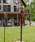 60 Inch Bamboo Torches 4-Pack With Easy Pour 12 Oz Canisters, Long-Lasting Fiberglass Wicks And Snuffers decorating a garden