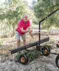 60 Inch Tow Behind Pine Needle Rake For Lawn Mowers, ATVs, And Tractors With 24 Tines, shown in use on rough terrain