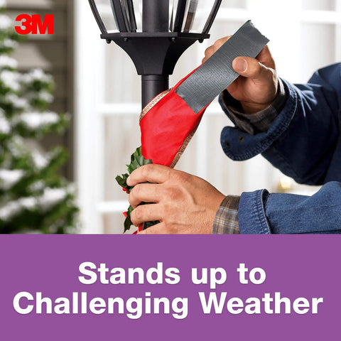 Person using No Residue Duct Tape 1.88 Inch By 20 Yards Grey 2420A Heavy Duty Adhesive on outdoor pole in challenging weather.
