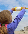 Child using Long Reach 500 Foot Kite Line Spool With 50 Lb Twisted Polyester For Kids And Grownups Bright Color Assortment