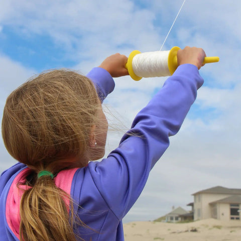 Child using Long Reach 500 Foot Kite Line Spool With 50 Lb Twisted Polyester For Kids And Grownups Bright Color Assortment
