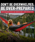 Woman relaxing in a red and black hammock overlooking a serene lake with forest and mountainous backdrop.
