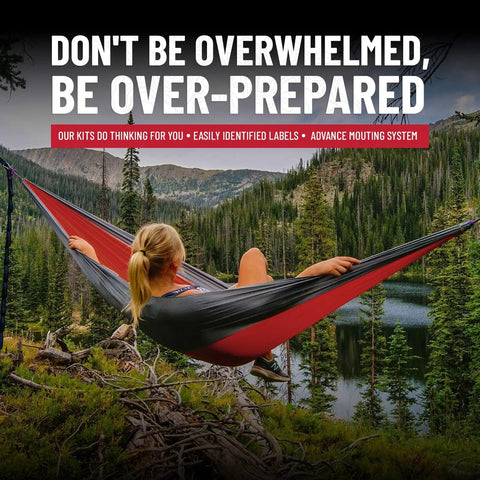 Woman relaxing in a red and black hammock overlooking a serene lake with forest and mountainous backdrop.