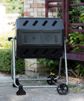 Dual Chamber Tumbling Compost Bin With Wheels, 37 Gallon Outdoor Garden Recycler, Elevated Rotating Bin in garden setting
