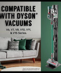 Docking Station Organizer And Vacuum Stand With Attachment Holder For Cordless Dyson V6 Through V15 And G5 Models Easy Drill Free Mount Keeps Tools Neatly Stowed Quick Access No Drill Holes beside a sofa.
