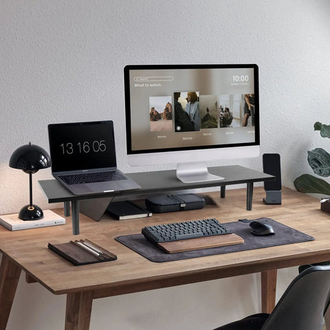Dual Monitor Stand Riser For Desk With Adjustable Length 32 To 40 Inches Space Saving Desk Shelf Organizer For Two Screen Setup Large Monitor Riser Stand For Computer Laptop PC Printer TV Black shown on a wooden desk holding a laptop and monitor.