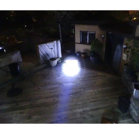 Two Pack LED Tactical Flashlights Water Resistant Military Grade 2000 Lumens lighting up outdoor wooden deck at night