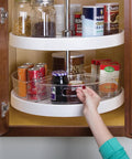 Hand reaches for jar in Clear Plastic Lazy Susan Cabinet Storage Bins Set Of 4 Quarter Wedge Containers for kitchen storage.