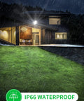 Beastly Bright 300W LED Flood Light illuminating house exterior and lawn in rain, showcasing IP66 waterproof feature