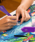 Hotfix Rhinestone Setter Kit With 7 Tips And Quick Heat Wand Diamond Bowl Stand Tweezers Cleaning Brush Wax Pens And 3 Boxes Of Colorful Crystals For DIY Embellishments And Jewelry Making Purple being used on a craft project.