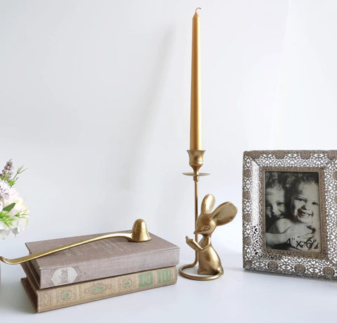 Image showing a long handled cast iron candle snuffer extinguisher tool for safe flame control and old school rustic vibe 9.8 inch reach candle care accessory next to a golden candle holder and framed photo.