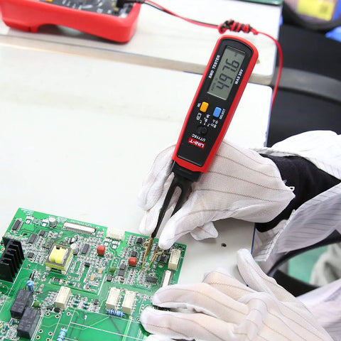 Technician using UT116C Pro Smart SMD Tester with Rotating LCD and Tweezers on circuit board