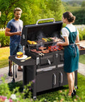 Two Independent Charcoal Grillin Zones With An Oversized 620 Square Inch Cooking Area Storage Cabinet Individual Lifting Charcoal Trays Foldable Side Tables And Built In Thermometer For Outdoor Patio Balcony in use at outdoor gathering