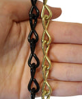 Hand holding black and gold chains, unrelated to Solid Steel Pendant Chain, 10 Gauge, 164-Foot Reel, Polished Nickel Finish.
