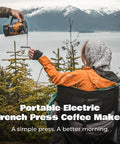 Person pouring coffee from Portable Camping Coffee Maker Electric French Press Travel Kettle 120V into a mug outdoors.