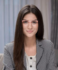 Young woman wearing red-frame glasses, sitting indoors. Not related to 4 Pack Safety Glasses Anti Fog Clear Goggles With Side Shields.