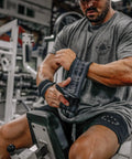 Man in a gym adjusting 18 Inch Heavy Duty Wrist Wraps For Weightlifting And Powerlifting With Ultra Strong Support For Bench Press, Deadlifts, Curls, CrossFit, And General Gym Workouts For Men