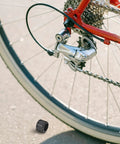Thru Axle Nut For Bicycle M15x1.5mm Aluminum Alloy Rear Fork Axle Nut With Easy Installation next to a mountain bike wheel