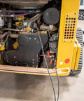 Construction vehicle engine with cables attached. Heavy Duty Battery Booster Cables 16 Feet With 500 Amp Clamps visible.