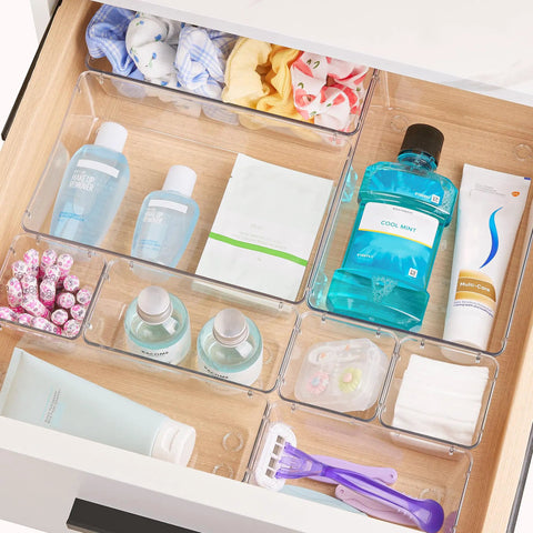 No Sweat 44 Piece Clear Plastic Drawer Organizers Set With Adjustable Vanity Trays For Bathroom Kitchen Office Craft Storage Makeup Cosmetic Tidying in a drawer with assorted beauty products.