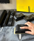 Pro Grade Set Of 7 Hand Sanding Blocks With PSA Base Auto Body Sanding Kit on a table with hand using block