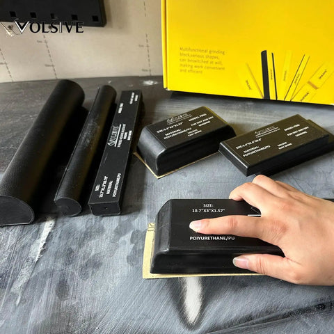 Pro Grade Set Of 7 Hand Sanding Blocks With PSA Base Auto Body Sanding Kit on a table with hand using block