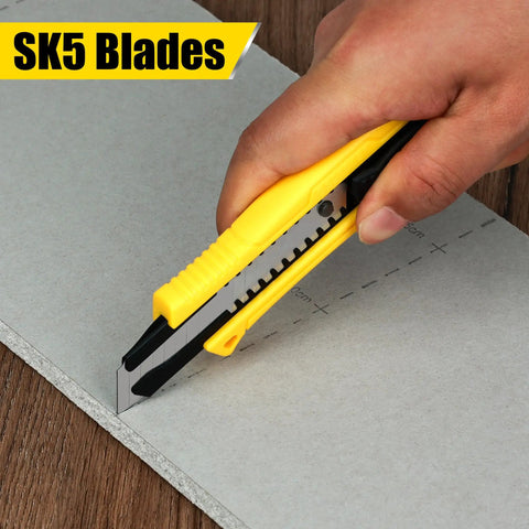Close-up of a hand using a yellow cutter knife with SK5 blades on a sheet, part of the 158 Piece Home Tool Set With Durable Chrome Finish Tools And Easy Carry Round Pouch, Hand Tool Kit For DIYers, Home Maintenance, Quick Fixes, Repairs, And Weekend Projects.