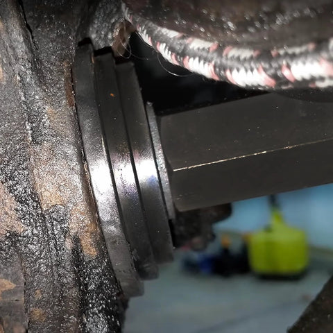 Close-up of Front Wheel Drive Bearing Press Kit 23 Piece Bearing Puller Set installed on a car's wheel hub, showing sliding screws.