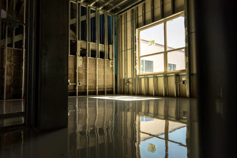No Sweat Setup Self Leveling Concrete Underlayment 50 Lb Bag Rapid Cure installed in a bright, partially framed room with polished finish.