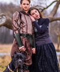 Couple wearing Medieval Viking Belt And Faux Leather Arm Guards Bracers Set 3 Piece For Cosplay, with a dog in the foreground.