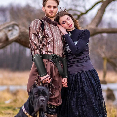 Couple wearing Medieval Viking Belt And Faux Leather Arm Guards Bracers Set 3 Piece For Cosplay, with a dog in the foreground.