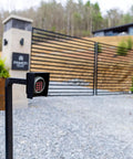 Beefy Universal Gate Keypad Mounting Post for Swing and Sliding Openers Weatherproof Iron Post in front of modern gate